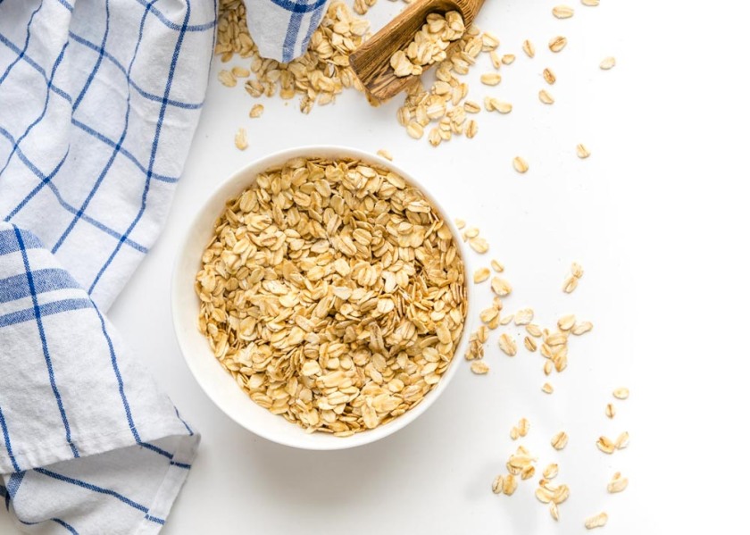 Rolled oats on white wooden background